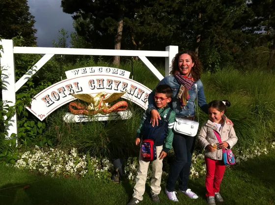 Mamá con sus dos hijos delante del cartel del Hotel Cheyenne
