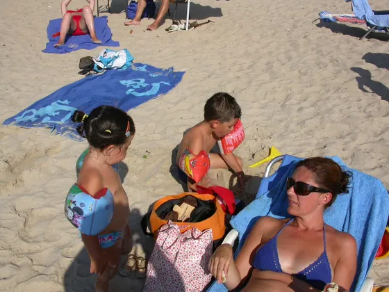 Mamá con sus hijos pequeños durante un día de playa